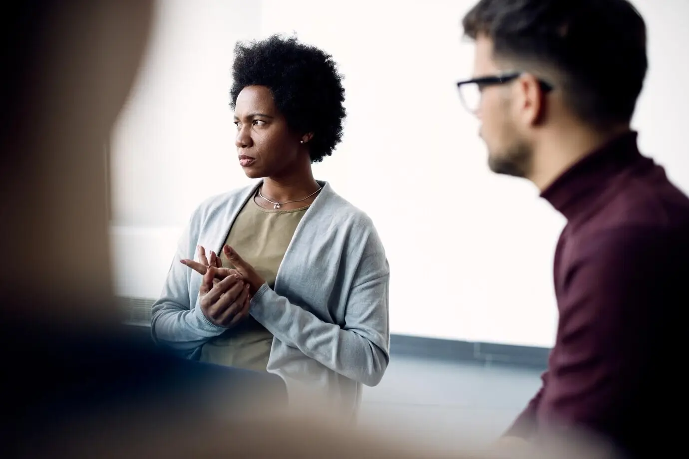 Eine afroamerikanische Frau spricht, während sie an einer Gruppentherapie im Gemeindezentrum teilnimmt.